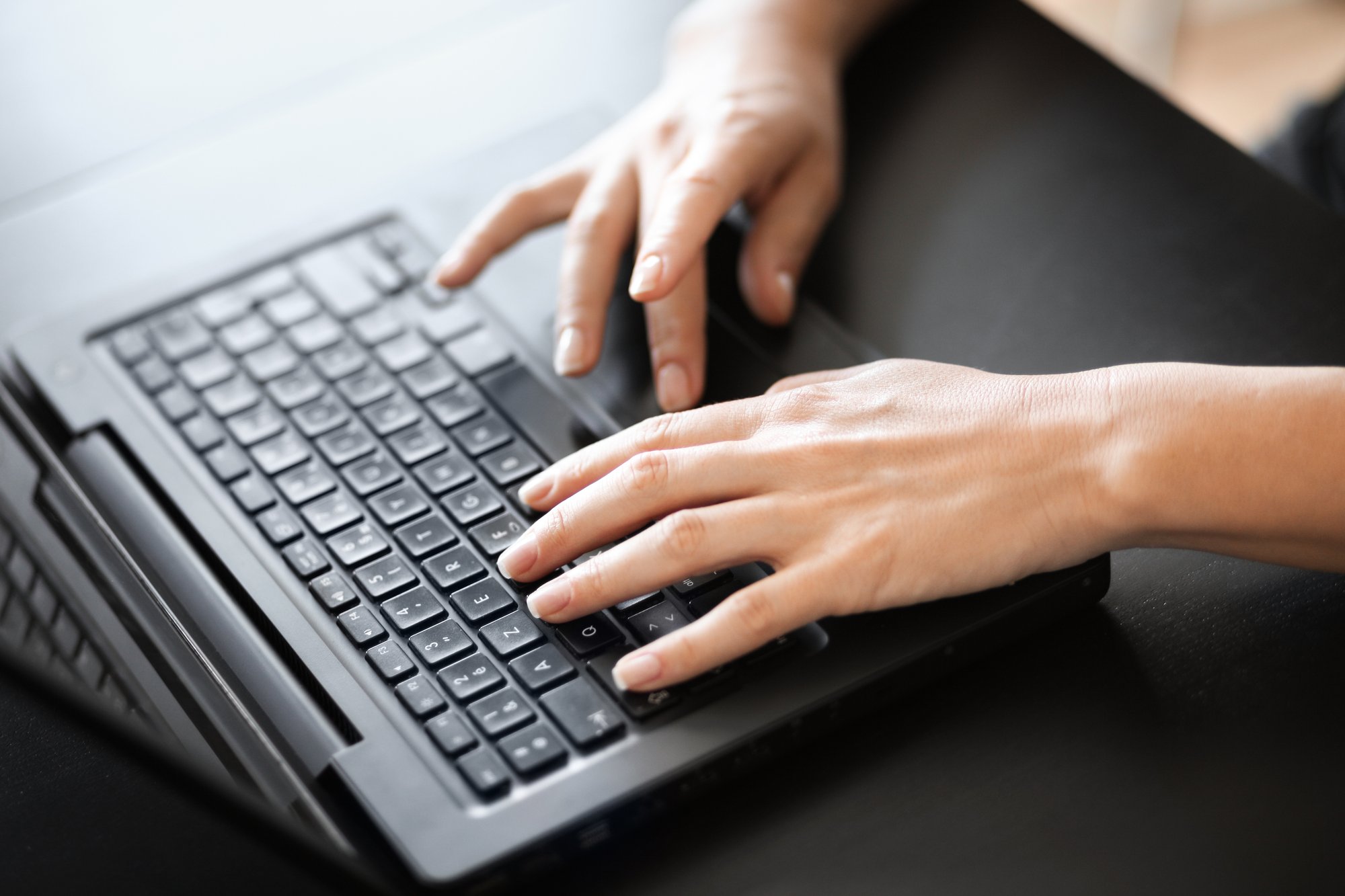 Hands of a Woman Typing on Laptop_Regulatory hosting_file231